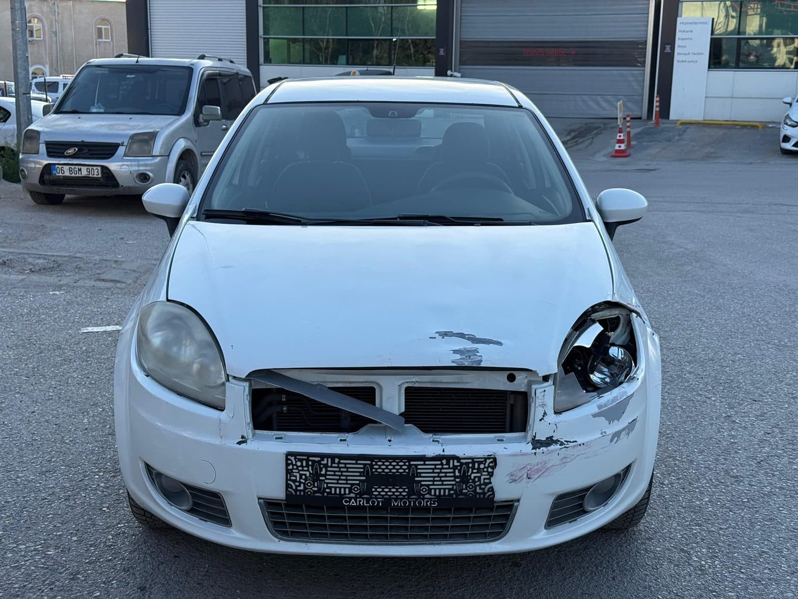 Ön tamponu ve farı hasarlı beyaz otomobil