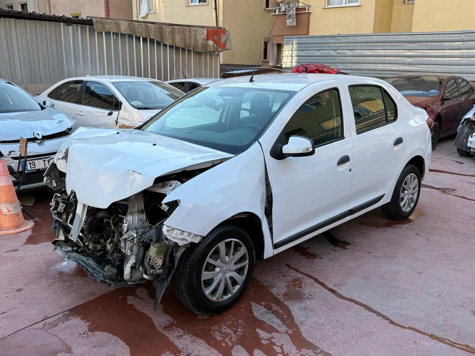 Ön tarafı ağır hasarlı beyaz sedan otomobil