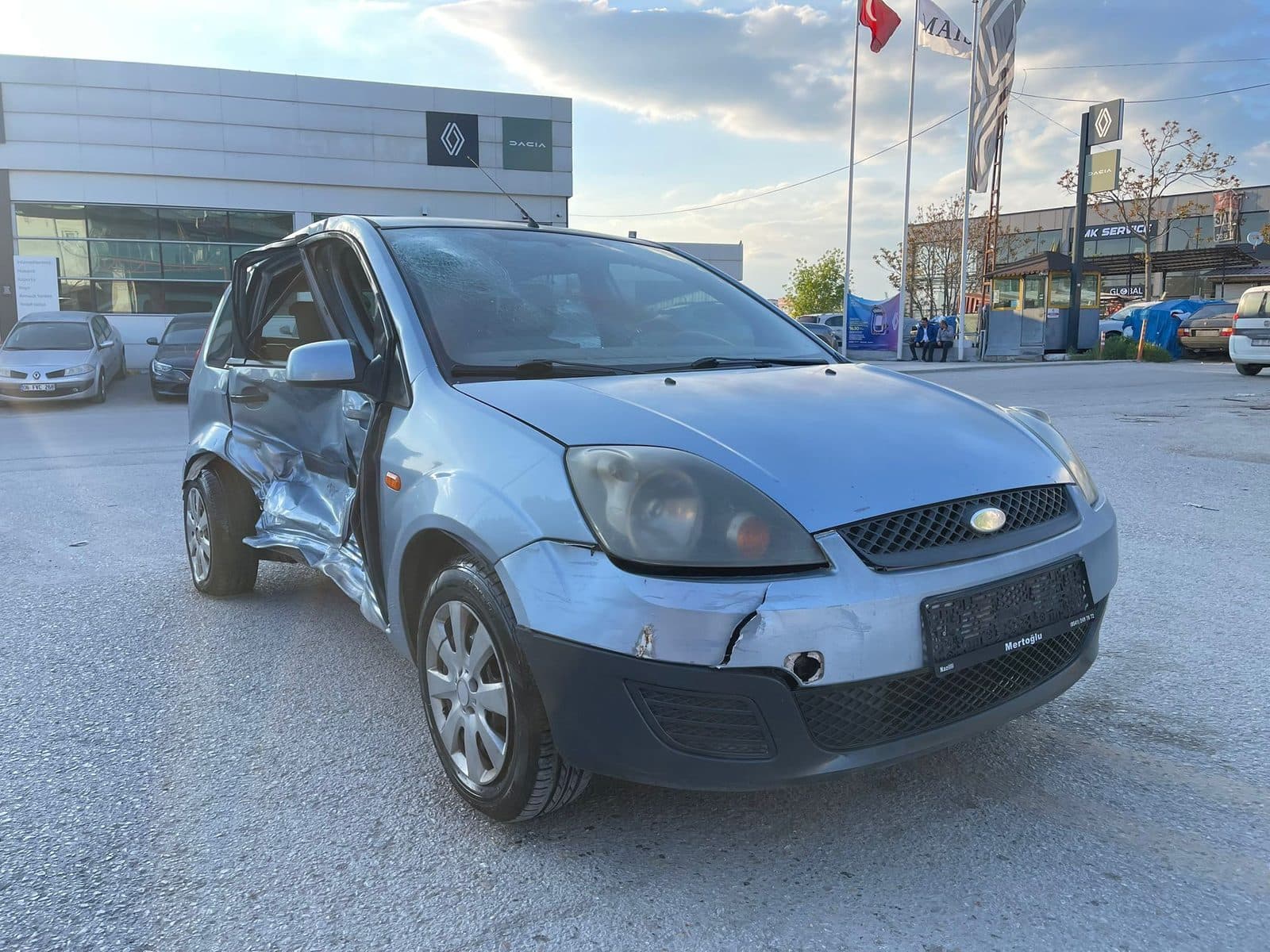 Ön sol tarafı hasarlı gri sedan otomobil