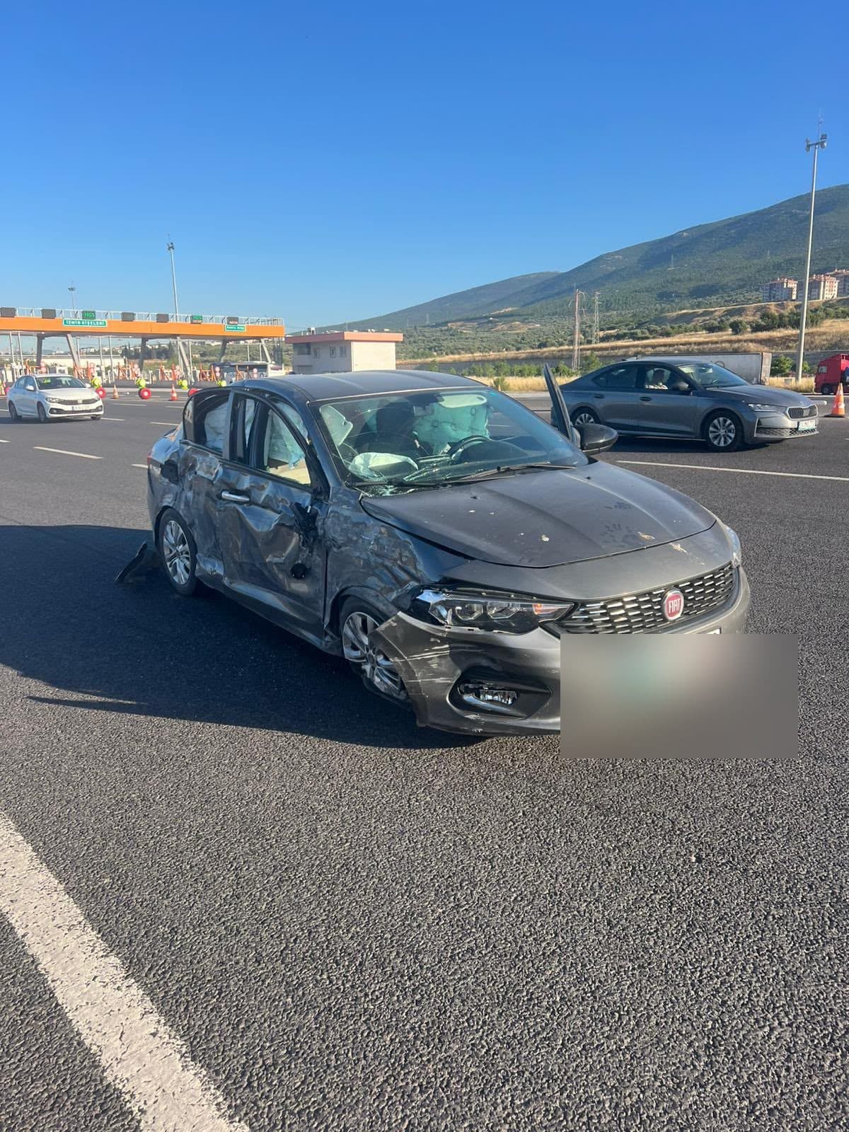 Yan tarafı kaza geçirmiş gri sedan otomobil yol kenarında